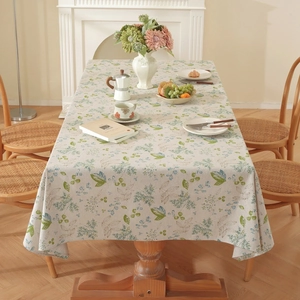 Detailed texture of cotton linen tablecloth with green leaf patterns in a cozy dining room