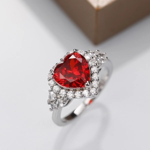Macro view of a silver ring featuring a heart-shaped red stone with pavé setting