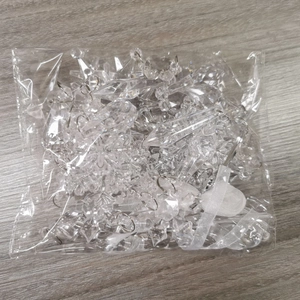 Detailed view of clear acrylic snowflake and icicle ornaments with metal rings on wood