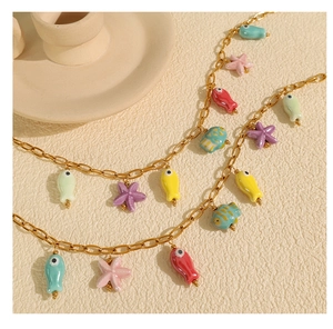 Detail of golden chain necklace featuring colorful ceramic fish and starfish charms