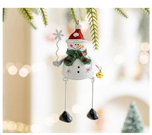 Close-up of a festive metal snowman ornament hanging on green pine branches with bokeh light