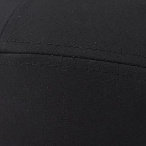 Makrodetail aus schwarzem Baumwoll-Canvas mit präzisen Doppelnähten auf der Baseballkappe