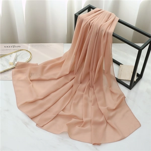 Detail of soft pink pearl chiffon scarf draped elegantly on a minimalist metal frame