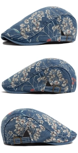 Detail of washed denim beret featuring floral print and bronze metal adjustment buckle