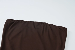 Detailed close-up showing the dark brown fabric texture and hem of the strapless dress
