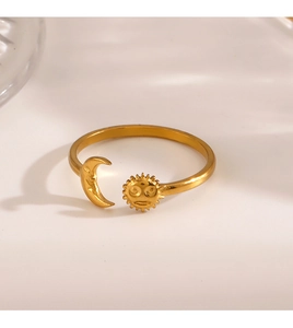 Macro detail of sun and moon engraved gold open ring on a clean minimalist surface
