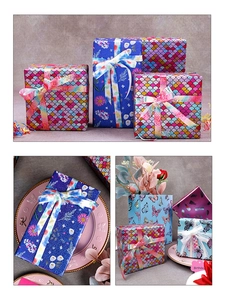 Detail of laser iridescent fish scale and floral gift wrapping paper with colorful ribbons