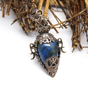 Detail of vintage copper lapis lazuli bottle pendant with star and heart engravings