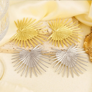 Macro detail of 304 stainless steel spike pendants in gold and silver finish on stone