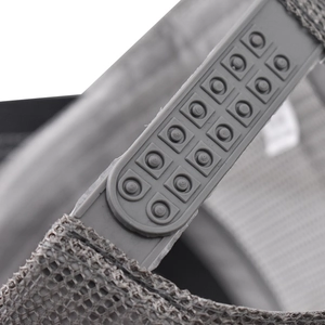 Macro detail of adjustable snapback closure and breathable mesh on a gray baseball cap