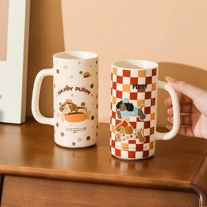 Cute ceramic puppy mugs with pink dots and red checkered patterns on a wooden surface