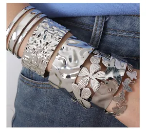 Detail shot of chunky hammered silver bracelet with intricate butterfly chain on wrist