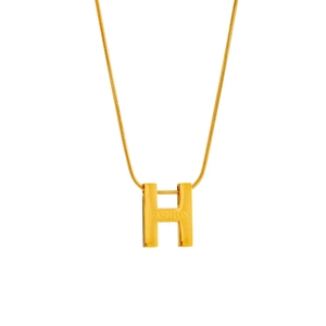 Detail of gold titanium steel H-pendant necklace with engraved fashion text