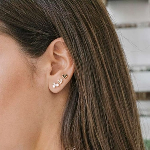 Close-up of S925 silver heart and diamond stud earrings set on a model's ear