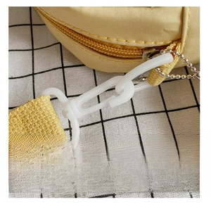 Detail view of the yellow canvas bag featuring detachable shoulder strap and plastic hook