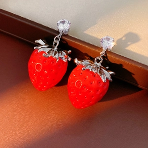 Dettaglio di orecchini a forma di fragola in resina rossa con strass nella scatola