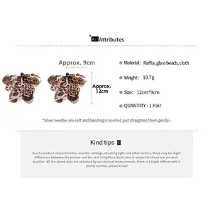 Detailed view of leopard print raffia flower earrings with glass beads and silver pins