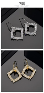 Detailed view of geometric square drop earrings with sparkling zircon inlay in gold and silver