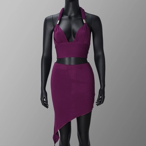 Detail view of purple knitted two-piece set with ribbed texture and irregular hemline