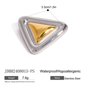 Detailed macro view of a dual-tone geometric triangle brooch in gold and silver finish