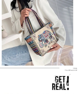 Detail of canvas tote bag with elephant embroidery and bohemian woven handles