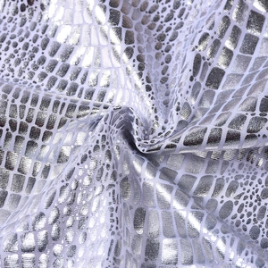 Detailed macro shot of silver metallic fabric with snake skin texture and glossy finish