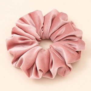 Close-up of oversized dusty rose velvet scrunchie with soft ribbed texture and elegant folds