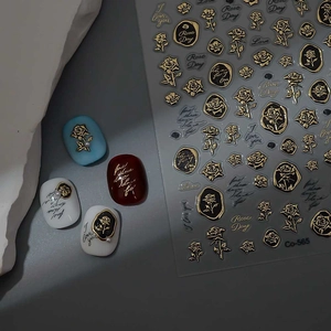 Detail of self-adhesive gold rose nail stickers with vintage floral patterns and text