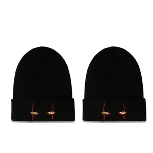 Two black knitted beanies with Pennywise eyes embroidery on white background