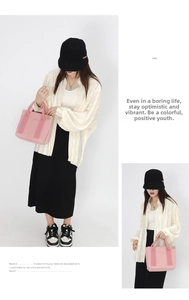 Detail of pink canvas tote bag styled with white striped shirt and black midi skirt