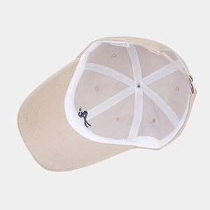 Detailed interior of beige baseball cap featuring a blue embroidered logo and sweatband