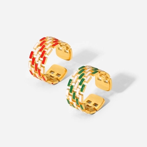 Detailed view of 18K gold plated C-shaped rings with red, green and white enamel inlay