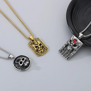 Detailed view of three gothic skull necklaces in gold and silver finish with red eye detail