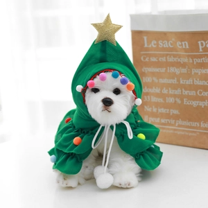 Close-up of dog Christmas tree cloak with gold star and colorful pom-poms on green knit