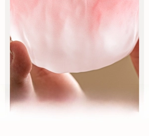 Detailed close-up of pink frosted glacier glass cup with hand-held tactile texture