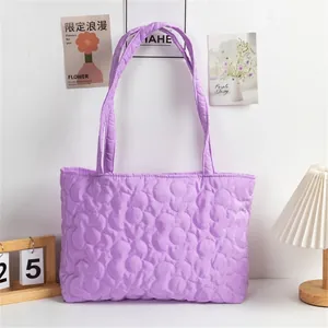 Detail of light purple quilted tote bag showing large dimensional floral patterns and nylon texture