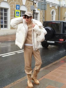 Chic winter white stand-collar puffer coat styled with beige knits and luxury handbag