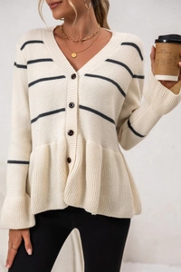 Detail of V-neck knitted cardigan with dark stripes and button closure in a casual city style