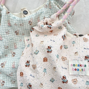 Detail of waffle fabric texture and cute cartoon animal illustrations on tote bags