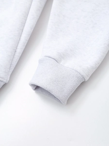 Close-up of elastic ribbed cuffs and soft fabric texture on the light grey sweatshirt