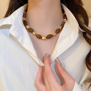Detail of vintage brown oval beads and gold irregular metal accents on a necklace