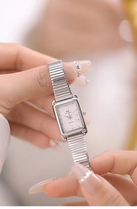 Macro shot of silver square quartz watch featuring Roman dial and flexible metal band