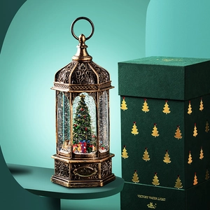 Vintage bronze Christmas snow globe lantern with rotating tree in an elegant green gift box