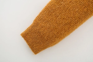 Close-up of ribbed cuffs on a brown knit sweater showing soft plush wool texture