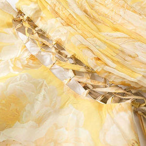 Detail of yellow floral dress featuring metal ring hardware and cutout lace-up design