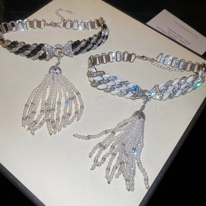 Detail of luxury chain necklaces with rhinestone Cuban links and hanging pearl tassels