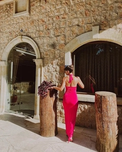 Back view of a backless halter neck long dress in rose red with flower patchwork details