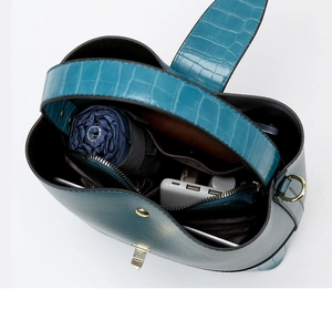 Detail of teal bucket bag showing spacious interior with pockets and textured leather