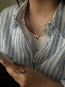 Macro detail of S925 silver heart necklace and ring set with black onyx inlay
