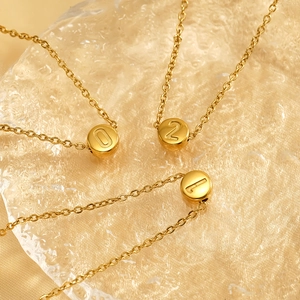 Three minimalist gold stainless steel necklaces with number 0, 1, and 2 round pendants